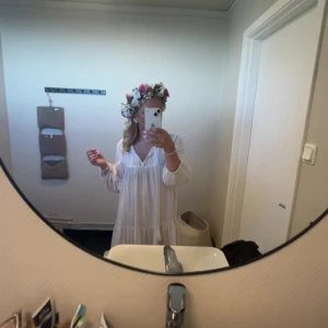 Vit kortklänning med volang - Superfin vit kortklänning i luftig bomull med v-ringning men går även att knyta vid halsen och långa ärmar. Inga fläckar eller liknande och är andvänd ett få tal gånger💗