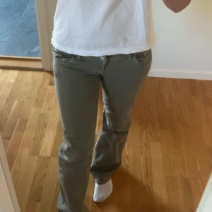 Gröna bootcut byxor i bomull - Snygga gröna byxor med bootcut-snitt och klassisk femficksdesign. Byxorna har låg midja och är tillverkade i mjuk bomull, vilket gör dem både bekväma och stilrena. Perfekta för dig som gillar en avslappnad men trendig look.