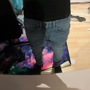 Blå jeans Burton Menswear - Säljer ett par ljusblå slimmy jeans från Burton Menswear London. Jeansen har klassisk femficksdesign, stretchigt material och smal passform hela vägen ner. Perfekta om du gillar en tajt look och vill ha bekväma jeans med lite tvättad känsla.