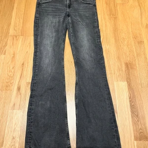 Svarta bootcut jeans från Gina Tricot - Säljer ett par svarta bootcut jeans från Gina Tricot i storlek 164. Jeansen har klassisk femficksdesign med snygga ficklock bak och är tillverkade i ett mjukt denimtyg. Perfekta för dig som gillar en lite vidare passform nertill.