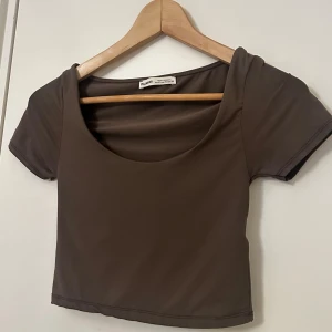 Brun croppad topp från Pull&Bear - Säljer en brun croppad topp från Pull&Bear med korta ärmar 
