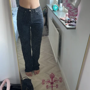 Svarta raka jeans med hög midja - Säljer ett par svarta jeans med hög midja och raka ben. Klassisk femficksmodell med knapp och dragkedja framtill. Jeansen har en enkel och clean look som passar till det mesta. Materialet är jeans och de sitter snyggt på kroppen.