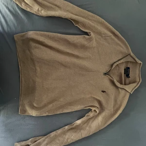 Beige half zip tröja från Polo Ralph Lauren - Säljer en beige långärmad tröja från Polo Ralph Lauren i mjuk pima bomull. Tröjan har half zip-dragkedja vid kragen och klassisk broderad logga på bröstet. Perfekt för lager-på-lager och chill stil.