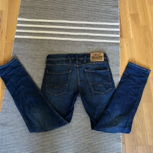 Replay Anbass slim jeans W28 L30 - Snygga blå jeans från Replay, modell Anbass Slim fit. Extremt bra skick. Supersköna och stiliga. Passar dig som är ca 170 (165-175)☺️Det är blå tvätt och den klassiska replay loggan på bakfickorna!👖🦅. Ett par perfekta jeans till höstens outfits 🤩✨. Nypris 1499. Skriv gärna om du har frågor eller funderingar!