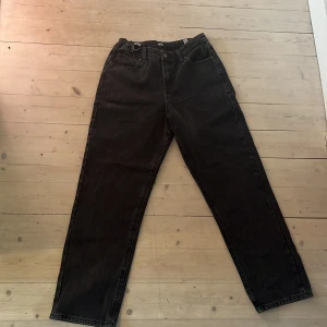 Svarta jeans från Jack & Jones - Säljer ett par svarta jeans från Jack & Jones med klassisk femficksdesign och raka ben. Jeansen har baggy passform och är tillverkade i bomull med en snygg mörk tvätt. Perfekta för dig som gillar en enkel och stilren look. Passar för dig som är runt 162-165