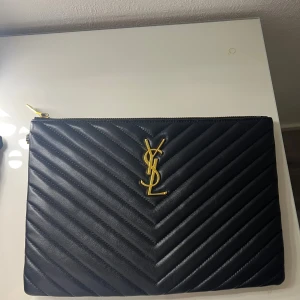 YSL clutch - Helt ny med alla tillbehör kvar,band, låda, dustbag, inplastad, storlek 30X20 cm. (Köpt från gula appen,därav priset)