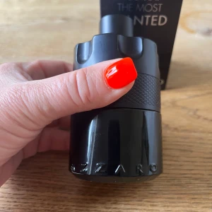 Azzaro The Most Wanted EdP 100ml - Azzaro The Most Wanted Eau de Parfum Intense i en cool, svart flaska med cylinderform och detaljerad textur. Flaskan har en unik design som påminner om en revolvertrumma och rymmer 100 ml. Perfekt för dig som gillar stilrena och maskulina dofter.använd ngn gång  men nästan full flaska