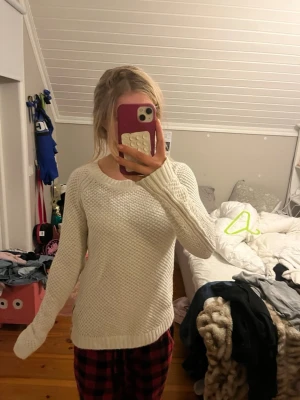 Vit stickad tröja från H&M - Snygg vit stickad tröja från H&M med rund halsringning och lång ärm. Tröjan har ett diskret stickat mönster och ribbade muddar vid ärmslut och nederkant. Perfekt att slänga på sig när det är kyligt ute.