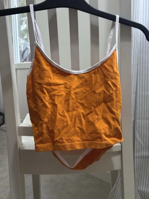 Orange linne med öppen rygg - Snygg orange topp med öppen rygg! Använd 1 gång. 