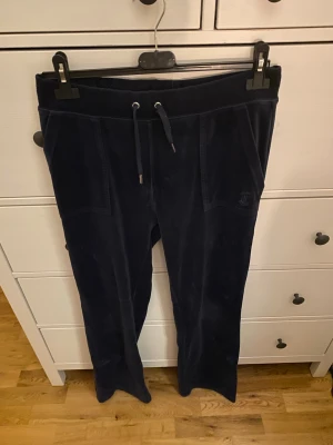 Juicy byxor  - Mörkblå juicy byxor i storlek M. Ena metallpluppen på snöret är borta som man kan se på sista bilden. 