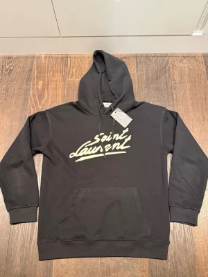 Saint Laurent hoodie - Säljer en fet Saint Laurent hoodie i storlek L men sitter lite mer som M. Hoodien är sprillansny och helt stilren. Bara att skriva vid frågor eller funderingar‼️