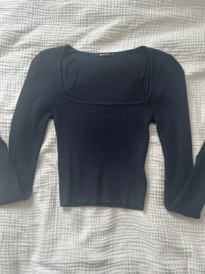 Marinblå stickad topp - En jättefin marinblå stickad topp från Gina Tricot. Använd några gånger men välbevarat. Har snygga slitsar längst ut i ärmarna och har en tajt passform. Superfin att klä både upp och ner. 