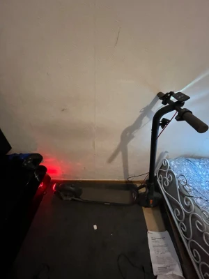 El scooter - Säljer en svart elscooter med digital display på styret och röda detaljer. Scootern har bred fotplatta, handtag med bra grepp och bakre stänkskärm. Perfekt för att ta sig runt i stan på ett smidigt sätt.