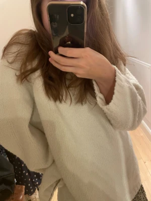 Vit oversized stickad tröja - Mysig vit stickad tröja med oversized passform och långa ärmar. Tröjan har en enkel design utan synliga detaljer eller mönster och är perfekt att slänga på sig för en avslappnad look. Materialet ser mjukt och fluffigt ut. Säljer då den är för stor åt mig!🫶 skriv för fler bilder och jag är öppen för prisförslag!!