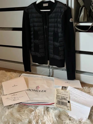 Svart cardigan jacka från Moncler - Snygg svart cardigan jacka använd fåtal gånger, fick den för ett år sedan i present av mina föräldrar, jackan är i nyskick inga defekter finns. Snygg att ha till våren eller en kallsommsrkväll. Äktahetsbevis medföljer samt påse och kvitto, skriv gärna för mer frågor ❣️