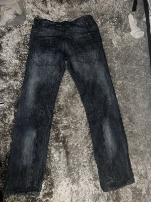 Mörkblå raka jeans med slitningar - Snygga mörkblå jeans med raka ben och diskreta slitningar. Klassisk femficksmodell med normal passform och midja. Perfekta till en avslappnad stil och lätta att matcha med olika toppar.