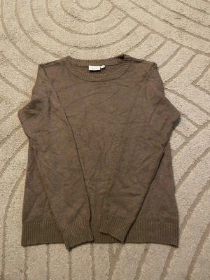 Beige stickad tröja från Vila - En stilren beige stickad tröja från Vila med rund halsringning och ribbade muddar vid ärmslut och nederkant. Tröjan har en klassisk passform och är perfekt för lager-på-lager. Materialet känns mjukt och bekvämt. Kan va lite nopprig. Använd gärna köp nu❤️