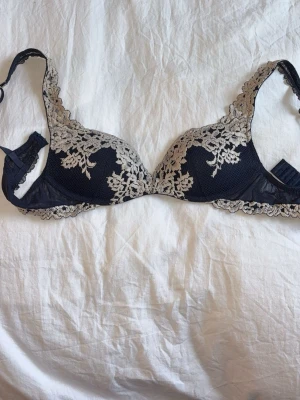 Mörkblå spets-bh med blommönster - Säljer min Snygga mörkblå bh. Bh:n har justerbara axelband. Perfekt för dig som gillar detaljer och stil. Den är använd men i fin skick. Vid snabb affär kan vi diskutera priset❣️