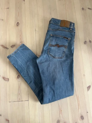 Nudie jeans  - Ljusblåa jeans i modellen Lean Dean från nudie jeans, storlek 31/32 sitter bra på längden på mig som är 180 men lite stora i midjan, super bra skick, skriv vid frågor!