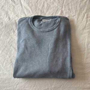 Ljusblå stickad tröja Kappahl  - Säljer en stilren ljusblå stickad tröja från Kappahl. Tröjan har rund halsringning, långa ärmar och ribbade muddar vid ärmslut och nederkant. Perfekt för lager på lager och enkel att matcha med jeans eller kjol.