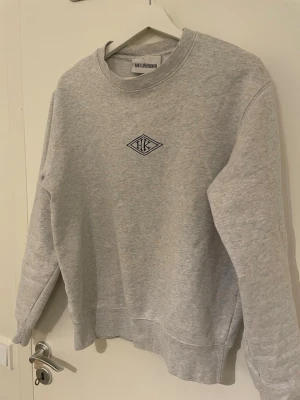 Grå sweatshirt från Han Kjøbenhavn - Snygg grå sweatshirt från Han Kjøbenhavn med broderad HK-logga på bröstet. 