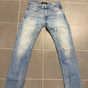 Replay ljusblå raka jeans Rocco - Säljer ett par ljusblå jeans från Replay, modell Rocco. Jeansen har klassisk femficksdesign, raka ben och snygga slitningar framtill. Tillverkade i mjuk bomullsdenim med Replay-logga på myntfickan. Perfekta för en avslappnad och trendig look.