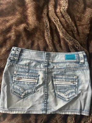 Ljusblå jeanskjol med fickor - Snygg ljusblå jeanskjol i kort modell med klassiska fickor med dragkedjor. Stl 36, midjemått tvärs över 39. Hör av er vid frågor❤️