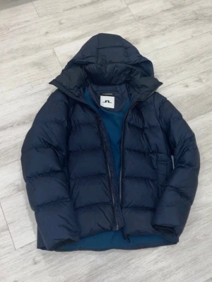 J Lindberg jacka  - Säljer denna helt nya J Lindberg vinterjackan. Storlek M och mörkblå. Jackan är helt ny men har en liten defekt vid ryggen där de finns ett litet sytt område som knappt syns(Bild 3 och 4) nypris ca 5000 kronor mitt pris endast 2499. Hör av dig vid minsta lilla fundering! 