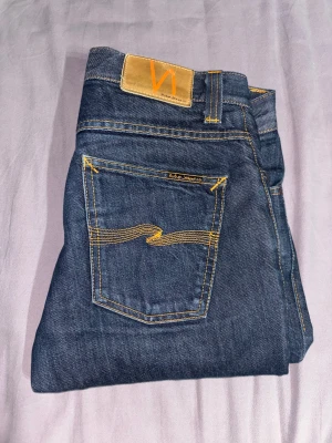 Nudie Jeans blå - Säljer ett par mörkblå jeans från Nudie Jeans i storlek W30 L32.  Bara använda ca 5 gånger då jag köpte fel storlek och dem är för små.  Modellen är trim grim.                                             Skriv om du undrar något. Svarar alltid snabbt