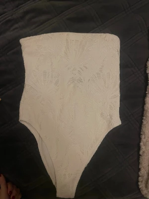 Vit spetsbody från H&M med öppen rygg - Säljer en vit spetsbody/baddräkt från H&M.