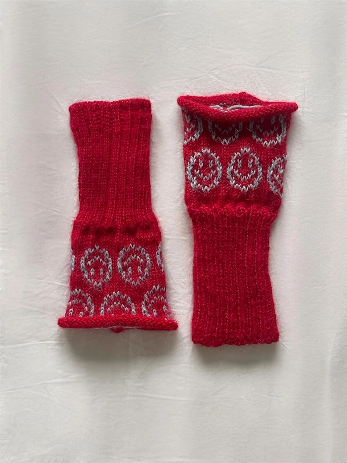 Röda stickade handledsvärmare i alpackaull