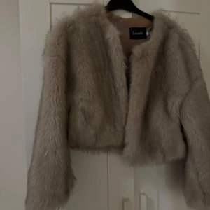 Ny pälsjacka  - Säljer en fluffig och snygg beige pälsjacka. Helt ny oanvänd.