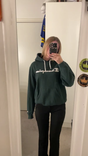 Champion huvtröja mörkgrön  - Snygg champion hoodie i mörkgrön färg med mörkblå färg inuti luvan. Väldigt varm och bekväm i fint skick. 