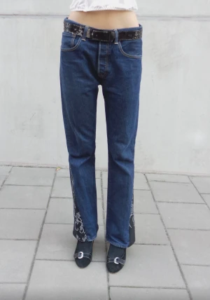 Siri Jeans - Mörkblå Levis jeans med svart tramp stamp och svarta detaljer.                                                                   Storlek: midja-83cm stuss-106 innebenslängd-78cm