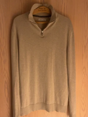 Beige half zip tröja Jack & Jones XS - Snygg beige långärmad tröja från Jack & Jones i storlek XS. Tröjan har en stilren half zip-dragkedja vid kragen och är tillverkad i mjuk bomull. Perfekt för dig som gillar enkel och clean stil med lite extra edge.