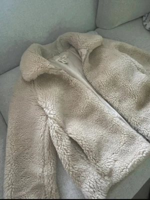 Beige teddyjacka från L.O.G.G XS - Mysig teddyjacka i beige från L.O.G.G, storlek XS. Jackan har fluffigt material, klassisk krage och dragkedja framtill. Perfekt för dig som gillar en chill och trendig look under kyliga dagar. Är nog i lite oversize stil. Jag använde den när jag var S. Funkar i M också. 