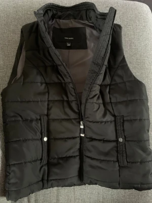 Svart pufferväst från Vero Moda - Snygg svart pufferväst från Vero Moda. Perfekt att slänga över en hoodie eller tröja för extra värme. Mycket sparsamt använd, så i nyskick.