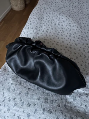 Svart skinn clutch handväska bikbok - Jättesnygg clutch från bikbok, stängs med magnet. Rymmer mycket,  toppen skick. Med innerficka.