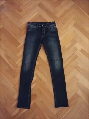 Replay Hyperflex jeans blå - Snygga Replay Hyperflex jeans i mörkblå tvätt med skinny passform. Klassisk femficksmodell, stretchigt material och diskreta slitningar framtill. Perfekt för dig som gillar tajta jeans med mycket rörelsefrihet. Märke och modell syns tydligt på etiketten.