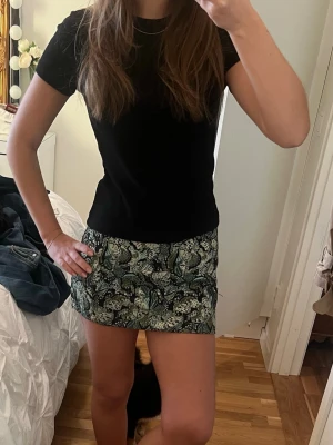 Svart kortärmad t-shirt - Säljer en enkel och stilren svart t-shirt med korta ärmar. Modellen är klassisk och passar perfekt till jeans, kjol eller shorts. T-shirten har rund hals och är gjord i mjukt material som känns skönt mot huden.