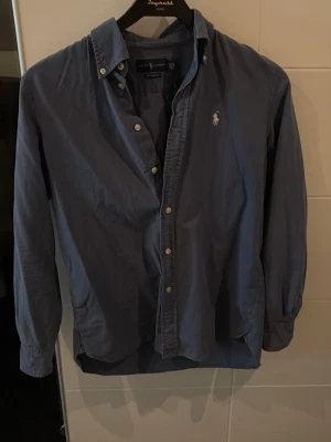 Blå skjorta från Ralph Lauren XS - Snygg blå skjorta från Ralph Lauren i relaxed. Mycket bra skick jag är 174 väger 54kg sitter lite tajt i armarna men bra i längd