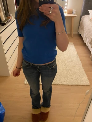 Blå stickad tröja från Lindex - Säljer denna fina blåa stickade kortärmade tröjan från Lindex. I väldigt fint skick förutom att lappen längst upp är bortklippt!