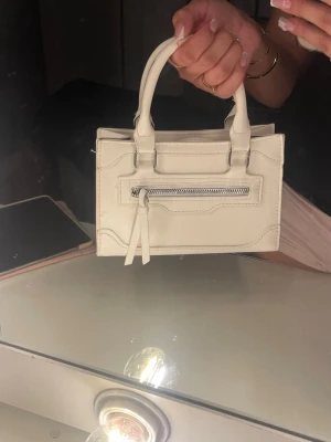 Vit handväska  - Snygg vit handväska som knappt är använd. Perfekt storlek för det viktigaste och passar till många olika outfits.