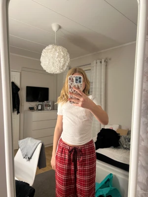 Vit snörad topp från Zara - Säljer en vit topp från Zara i storlek S. T-shirten har korta ärmar och cool snörning på båda sidorna som går att justera för en snygg passform. Materialet är mjuk bomull och modellen är normal i passningen. Perfekt för dig som gillar enkel men trendig stil.