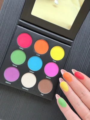 Over The Rainbow ögonskuggspalett - Färgstark ögonskuggspalett med 9 matta och skimrande nyanser: röd, orange, gul, grön, blå, rosa, lila, vit och brun. Paletten har spegel i locket och pigmenten är intensiva och lätta att blanda. Perfekt för kreativa och färgglada looks.