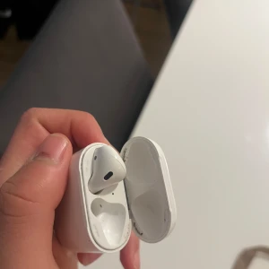 AirPods 2 finns endast ena hörlurarna - Apple AirPods 2 med laddningsetui. Trådlösa hörlurar med smidig anslutning till iPhone och andra Apple-enheter. Skick: synligt slitage och smuts på etuiet, men hörlurarna ser hela ut. Perfekt för dig som vill ha äkta Apple-ljud till ett bra pris.