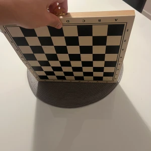 Ingen väst på bilderna - Bilderna visar ett schackbräde i trä med schackpjäser, ingen väst finns med på bilderna.