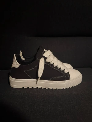  Numeris sneakers - Snygga sneakers från Numeris i svart och vitt med breda snören.  Skorna är inprincip helt nya, använda endast 3 gånger. Passar med allt från jeans till mjukis. Skorna är i storlek 41. Säljer skorna pågrund av att dem är lite stor.