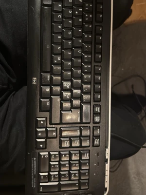 HP USB Keyboard - HP USB-tangentbord med nordisk layout. Tangenterna är tydliga och fungerar bra, men viss kosmetisk slitage syns på ytan. Perfekt för kontor eller hemmabruk. Fullstort med numeriskt tangentbord och multimediaknappar. Kabelanslutning för stabil användning.