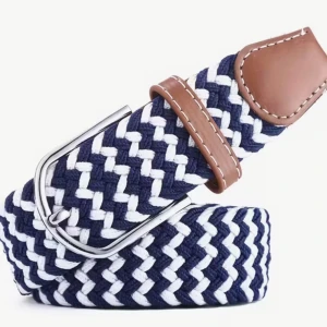 Blåvit flätad bälte med läderdetaljer - Snyggt flätat bälte i marinblått och vitt med bruna läderdetaljer och silverfärgat spänne. Perfekt för att ge din outfit en cool touch. Bältet har ett mönstrat utseende och passar till både jeans och chinos.